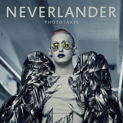 Albumcover von PHOTOTAXIS - Neverlander; ein Mensch, der einen futuristischen Umhang aus Metall und eine spiegelnde gelbe Sonnenbrille trägt, dazu weißes Makeup und schwarzen Lippenstift