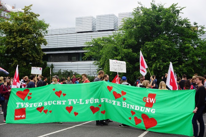 Streikende Studierende mit einem Banner mit der Aufschrift "TVStud Sucht TV-L für feste Bindung". 