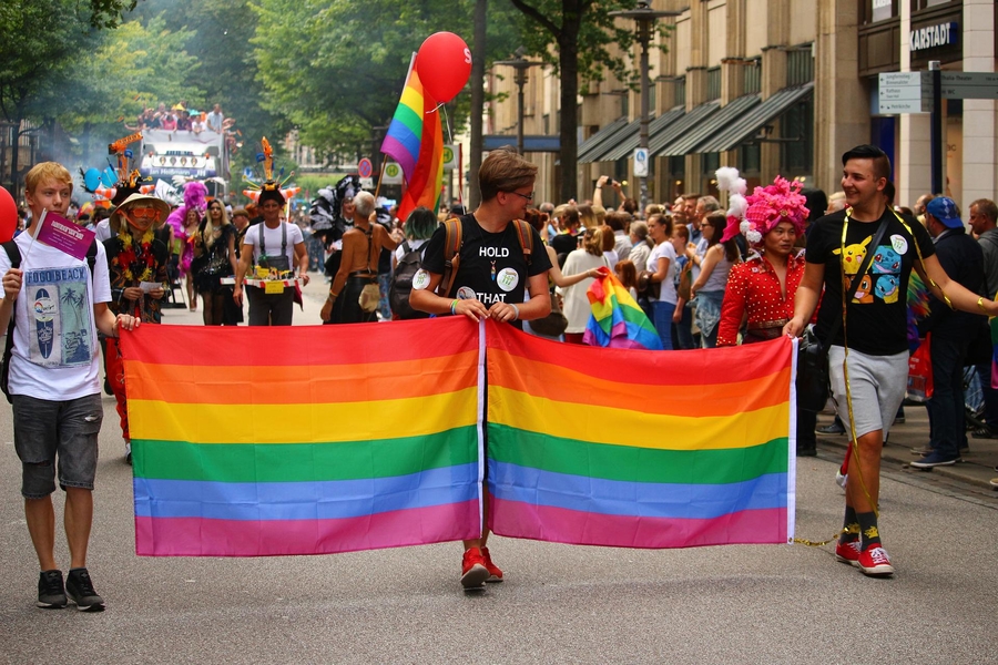 Demonstrierende hinter einer Regenbogenflagge