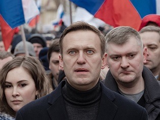 Mensch in Masse stehend, Blick nach oben, dahinter Flaggen Russlands