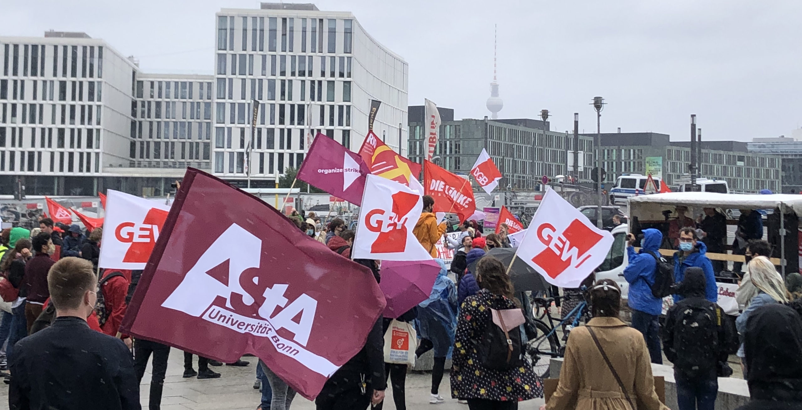 Demonstrierende Studierende mit roten Fahnen vor dem Hauptbahnhof in Berlin.