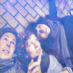 Cover von Yippie; Foto von einem weißen Mann und zwei weißen Frauen, die nebeneinander auf gepflastertem Boden liegen
