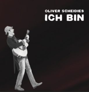 cover von Oliver Scheidies – Maskenball im Tanzpalast; Schwarzweiß-Bild des Artists, der singend mit einer Gitarre läuft, schwarzer Hintergrund