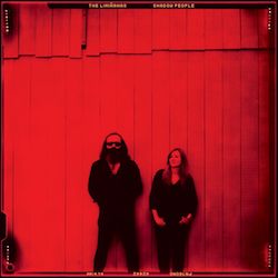 Albumcover von THE LIMIÑANAS - Shadow People; ein Mann und eine Frau in schwarzer Kleidung stehen vor einer Bretterwand. Das Bild ist leuchtend rot eingefärbt.